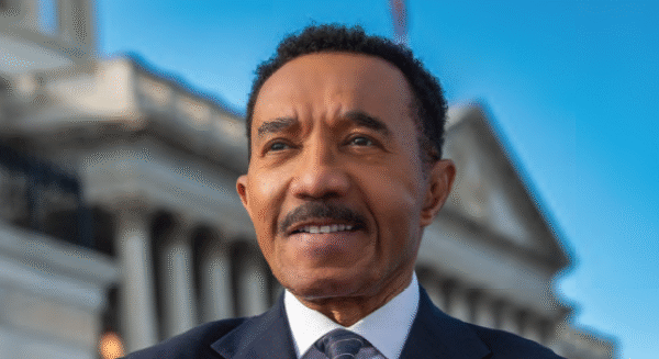 Congressman Kweisi Mfume stands on steps of US Capitol with arms folded. Image by P.A. Greene.